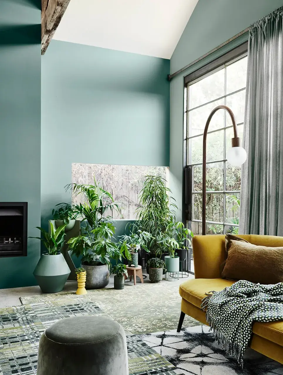 High ceiling interior living room with green wall and plants