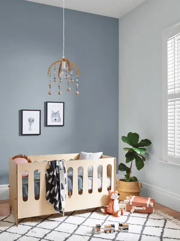 Nursery with timber cot, blue feature wall and white wall