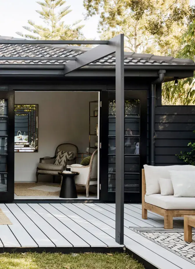 An exterior of a house painted black with black roof and trim