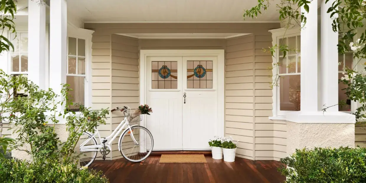 A house with weatherboards and white double wooden doors