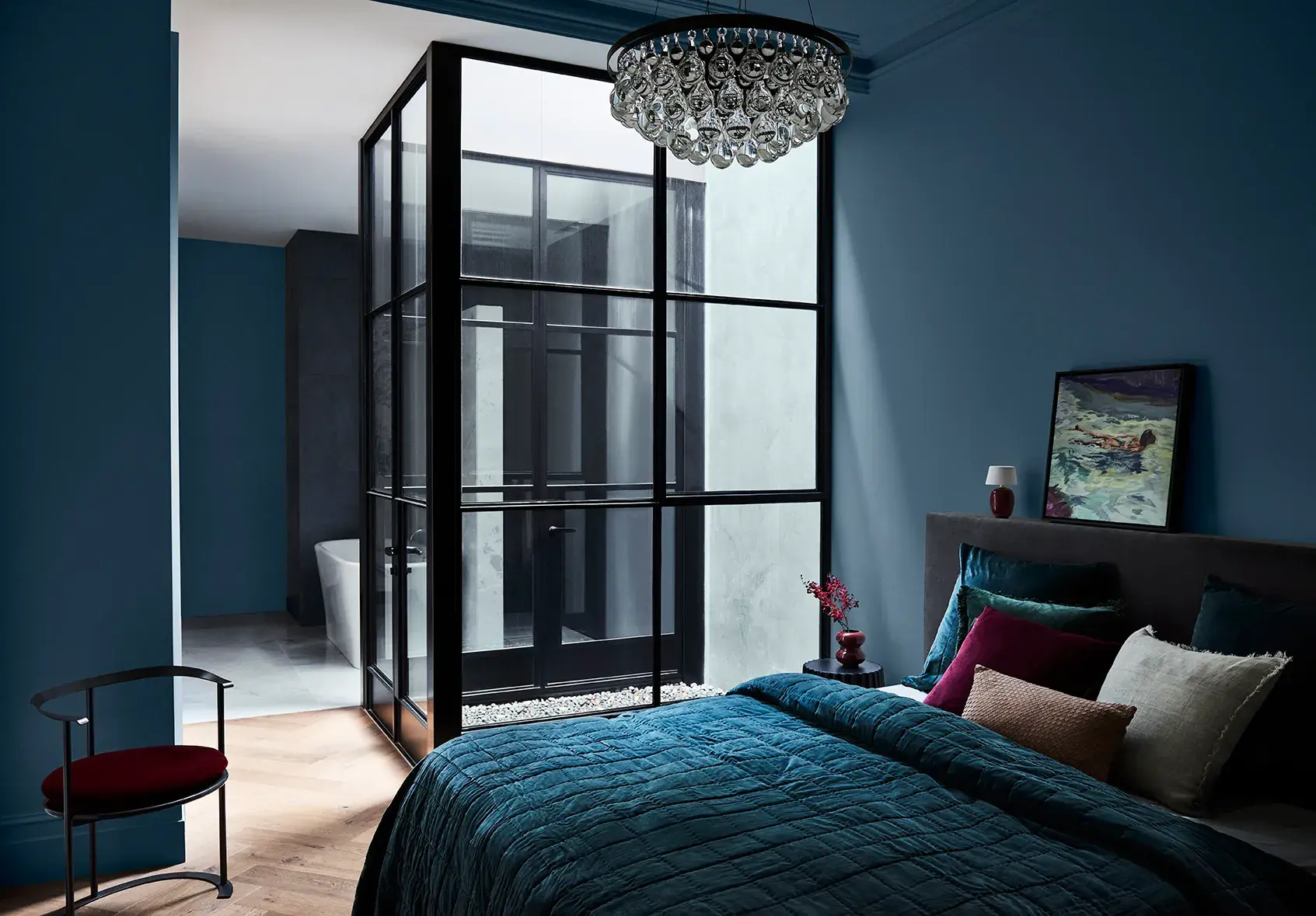 bedroom with dark blue walls and a chandelier 