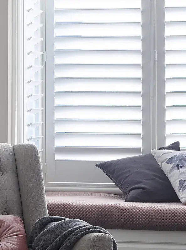 interior close up of window shutters and bench seat. 