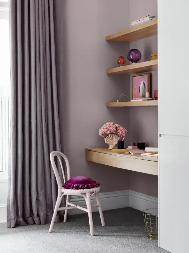 Built-in desk and bookshelves in light purple room