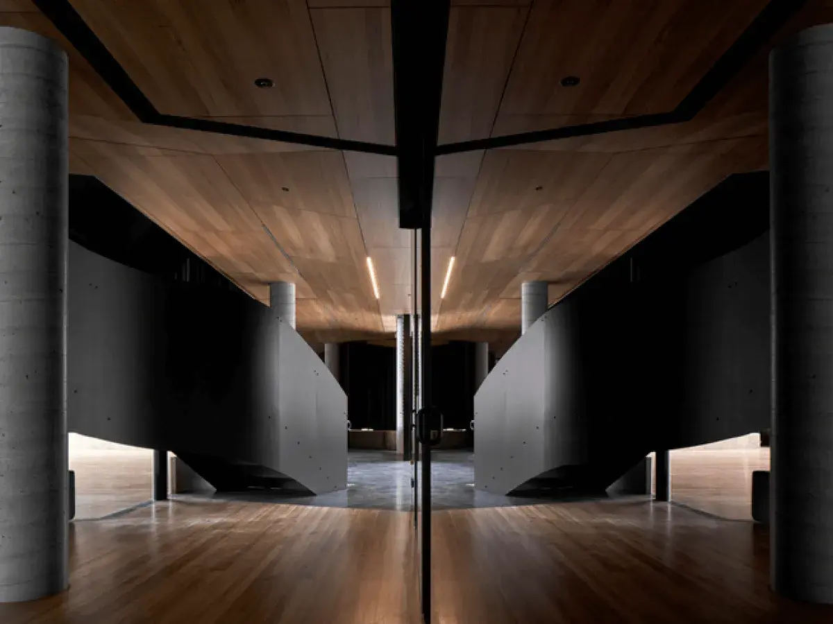 Curved staircases in room with wooden ceiling and floor