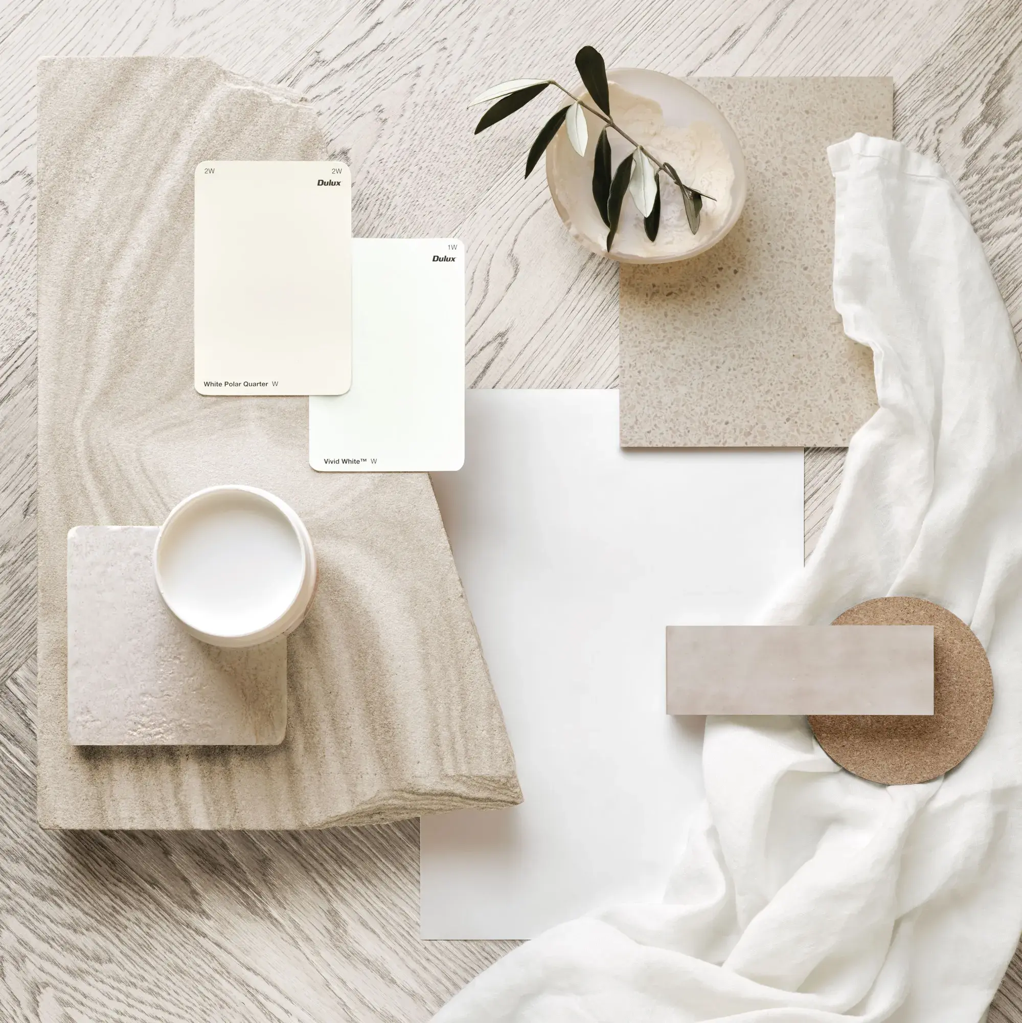 White and neutral paint sample chips on herringbone timber floor