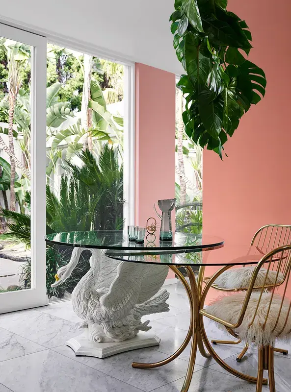 Two glass-topped tables in front of a salmon-painted wall