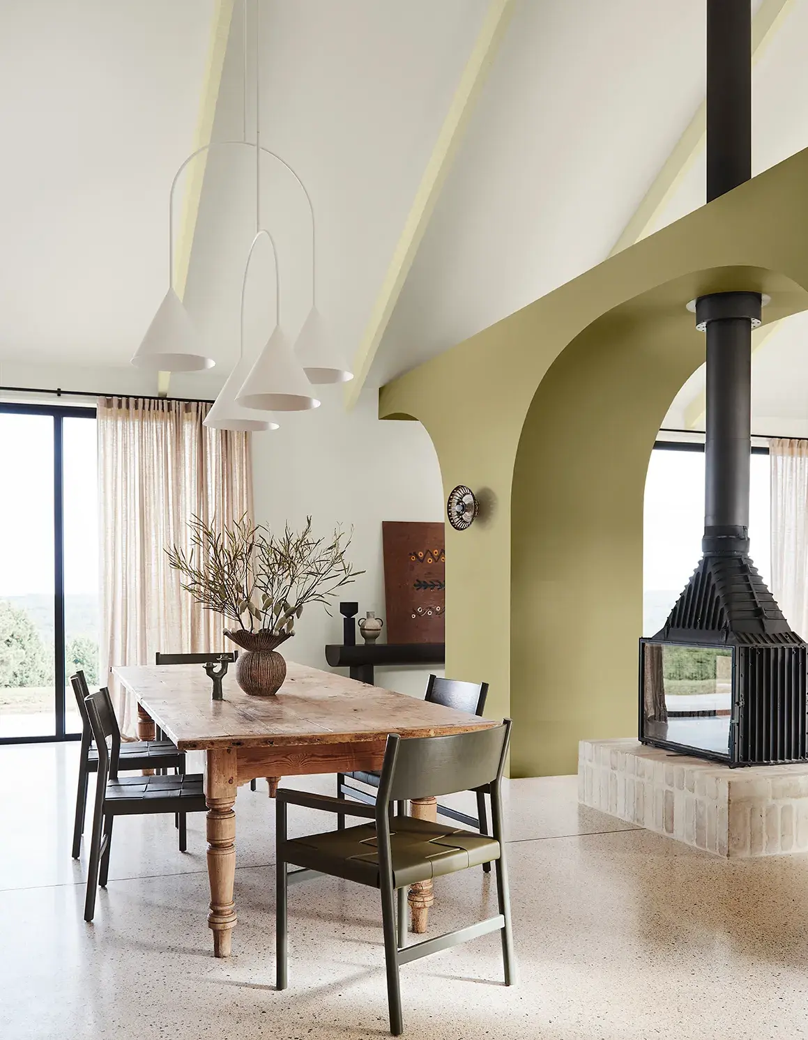 Spacious dining room with arched wall and black fireplace