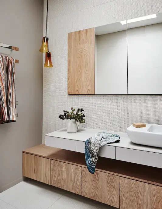 Bathroom vanity with timber cabinetry and amber pendent lighting