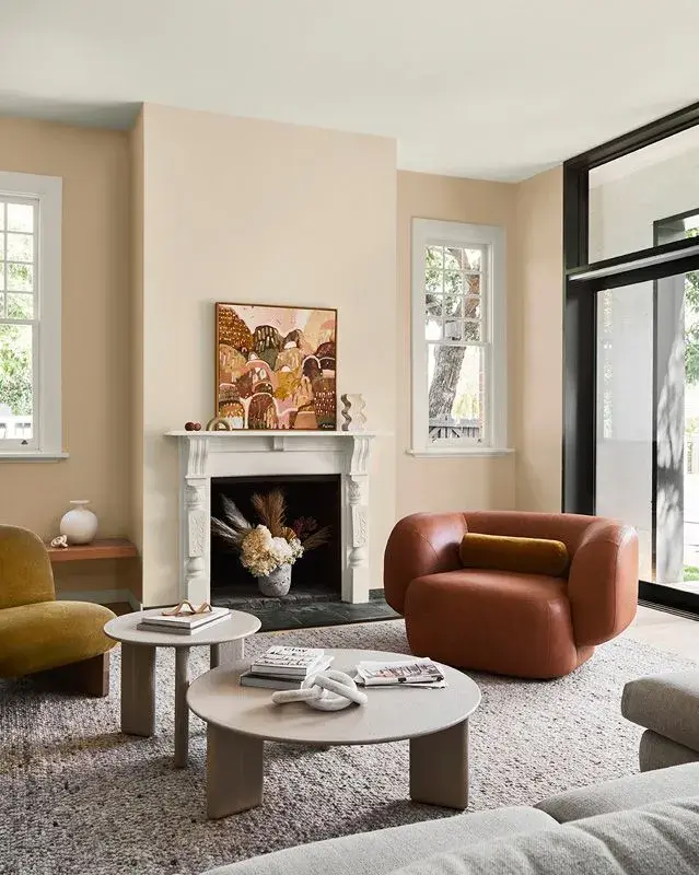 Living room with wooden round coffee tables with plants and vases on them