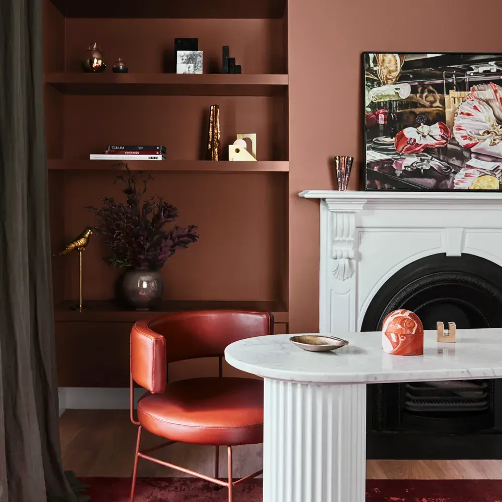 Study with marble desk, chair and fireplace. Painting above fireplace and decorative shelf items.