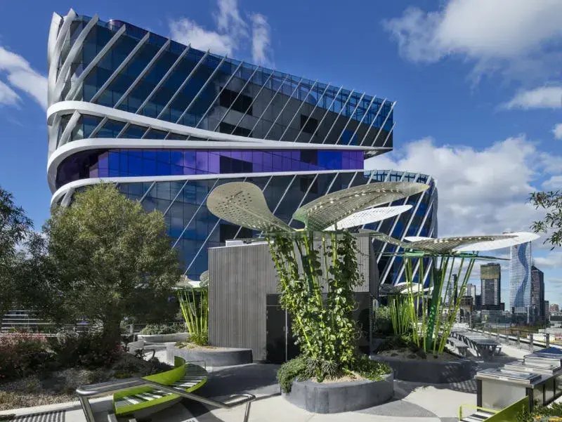 exterior blue building with green sculptures. 