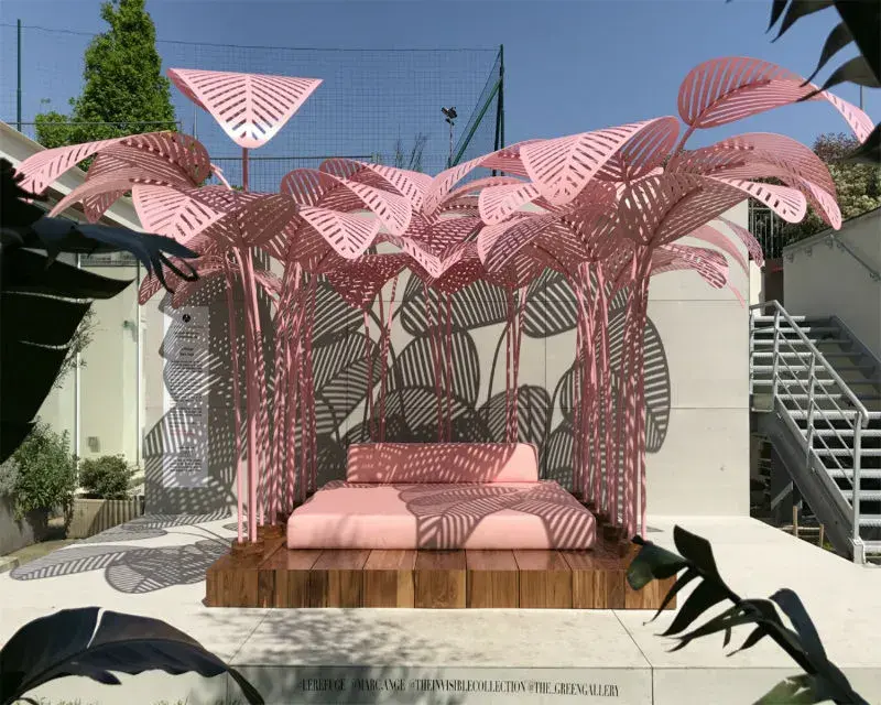 Pink metal palm fronds shading daybed exterior on show at Milan Design Week