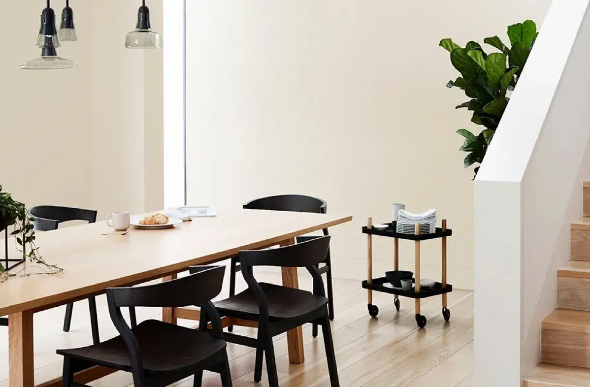 White interior dining room with timber dining table and black chairs