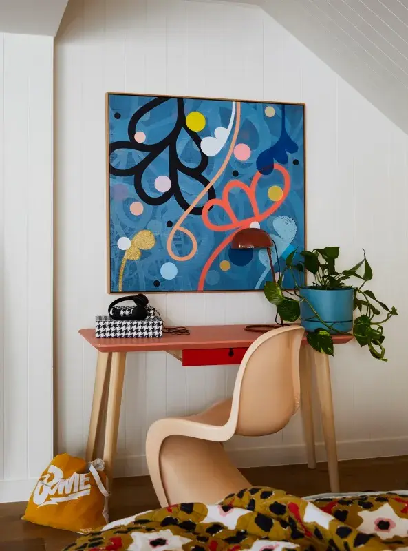 A apricot-coloured chair under a red desk