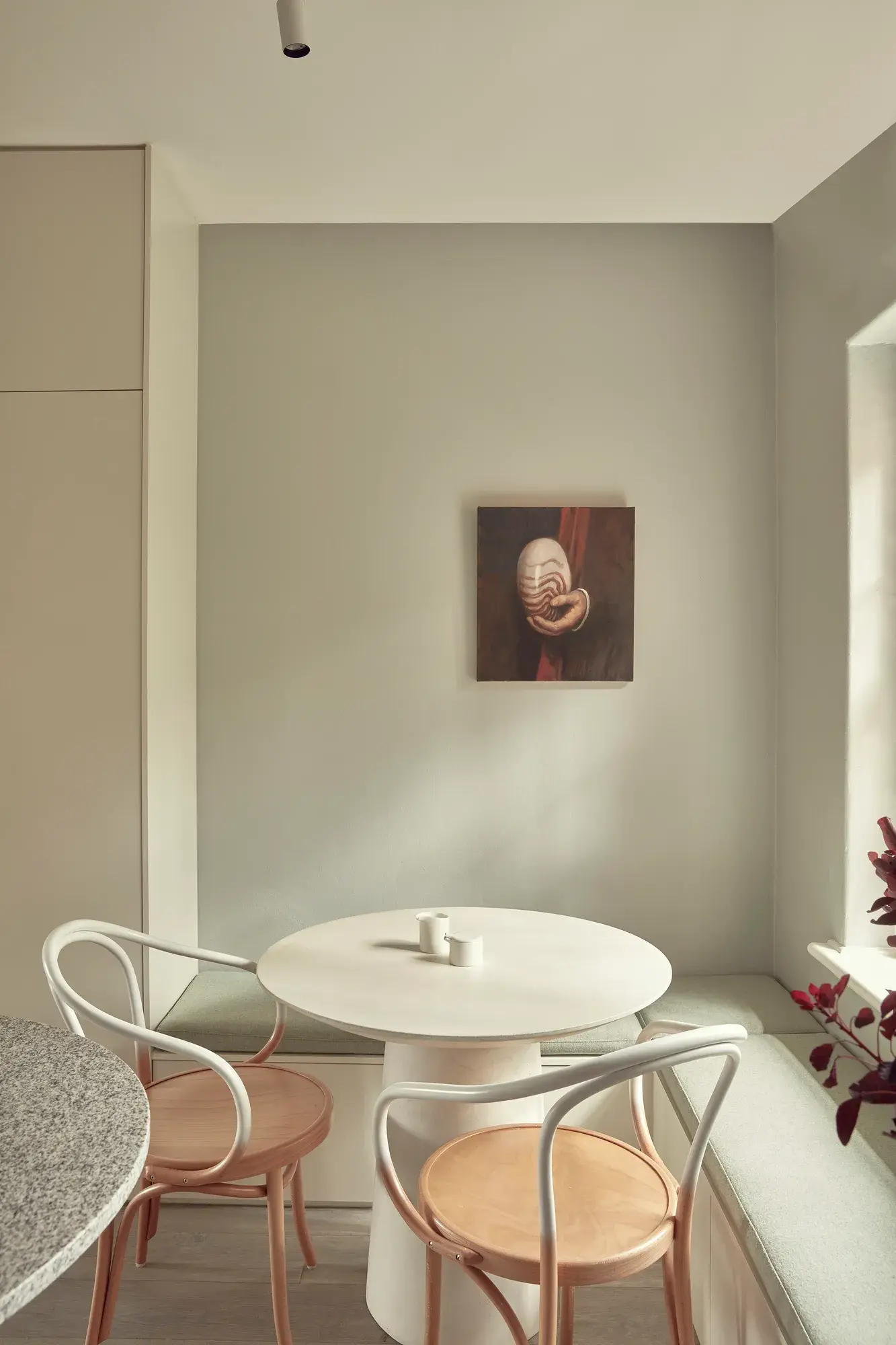 Round table in two bentwood chairs in neutral toom