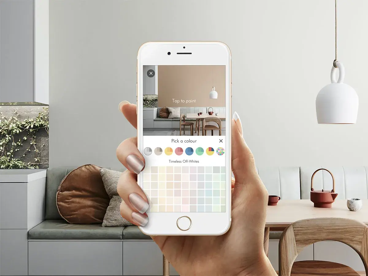 A hand holding up a phone with the Dulux Colour App open on it
