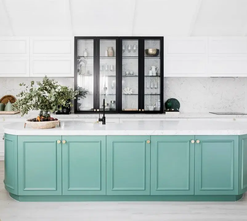 interior green kitchen island with a black shelf and white wall. 