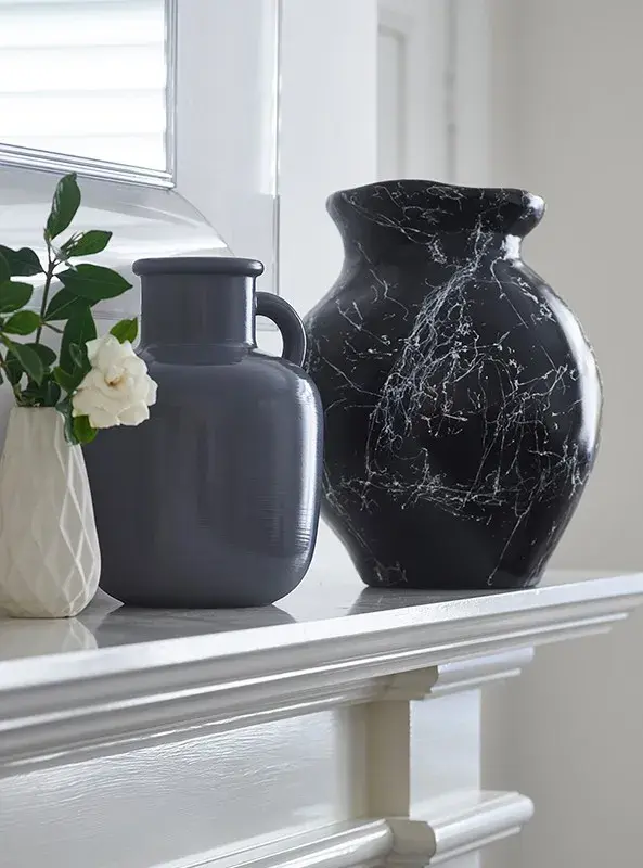 interior fireplace ledge close up of vases.