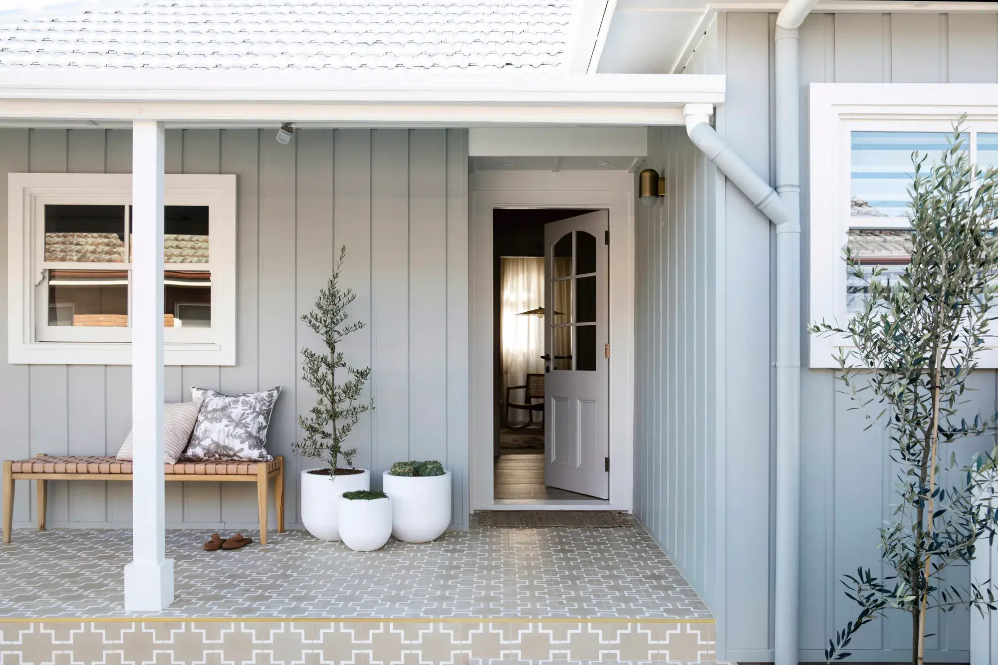 Grey house with white trim verandah and tiled patio