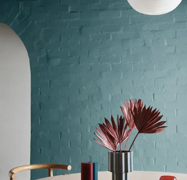 green dining room with decor on round timber table