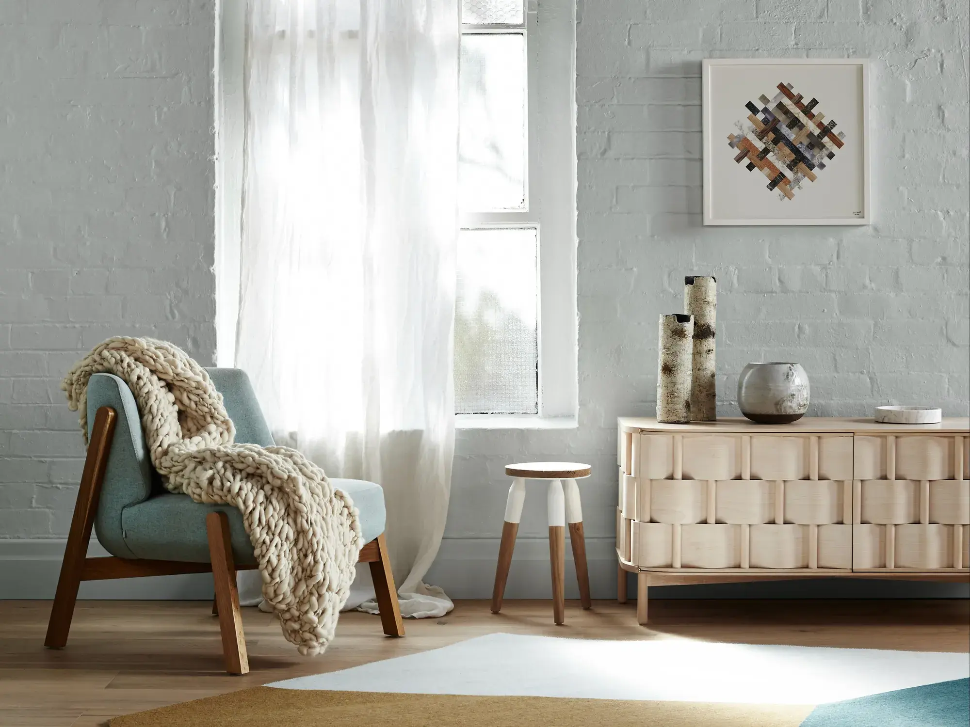 White painted brick interior wall with side table and arm chair