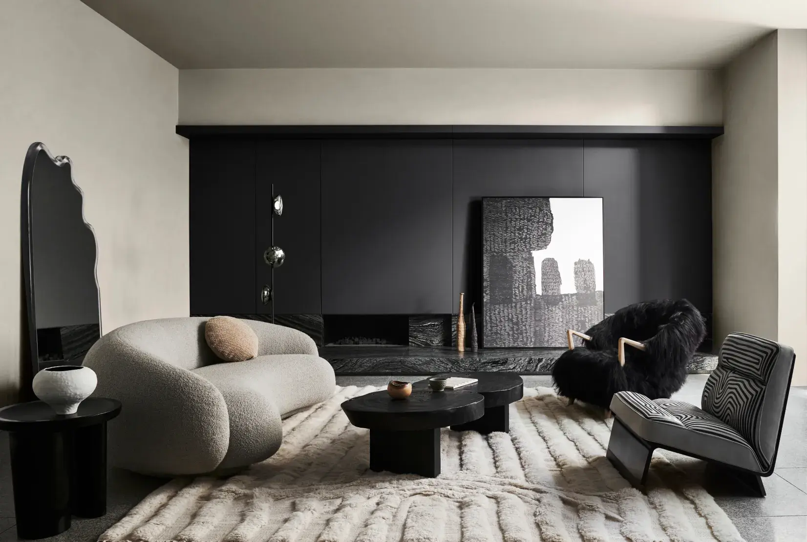 Interior living room with Black Caviar coloured feature wall and Opononi Double coloured supporting walls. The Space is decorated with plush grey and black furniture. 