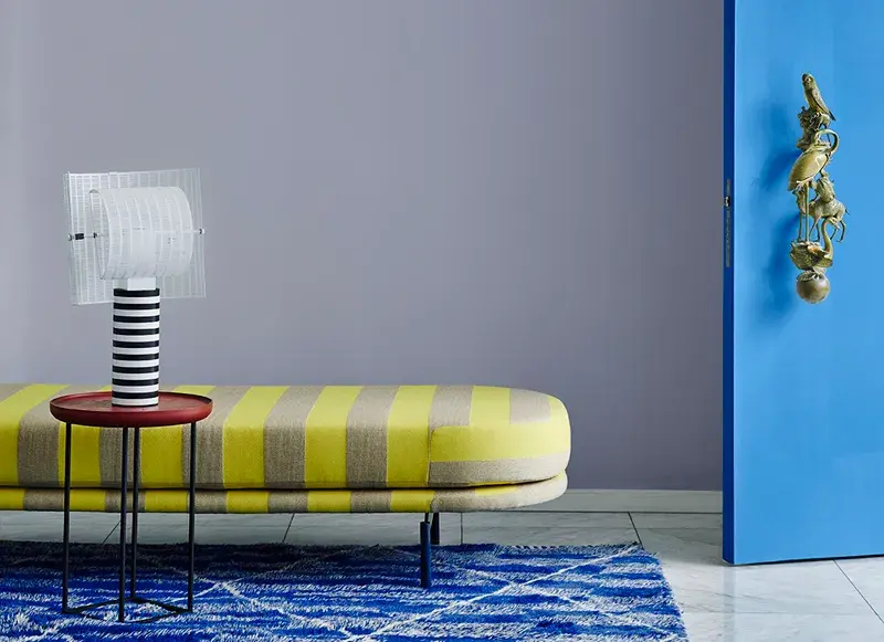 A yellow and grey striped seat next to a blue door