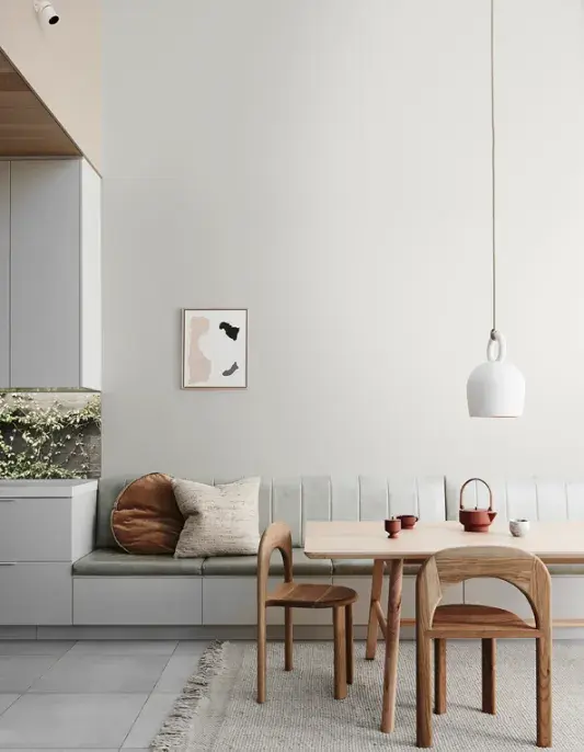 White interior dining area with Japandi timber dining table and bench seat