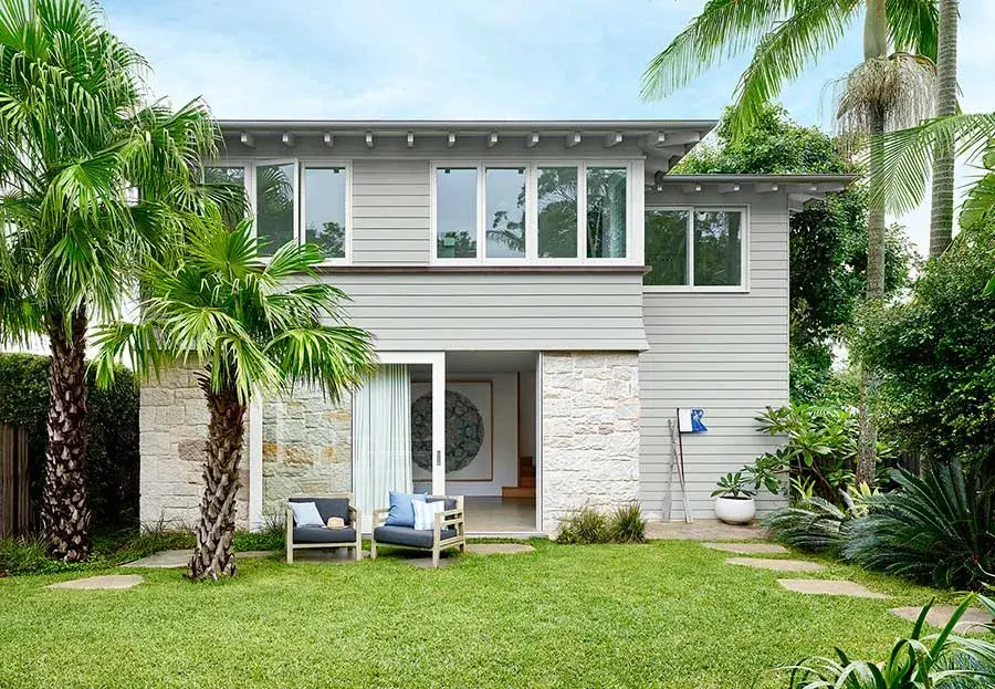 Grey house with white trim verandah and tiled patio