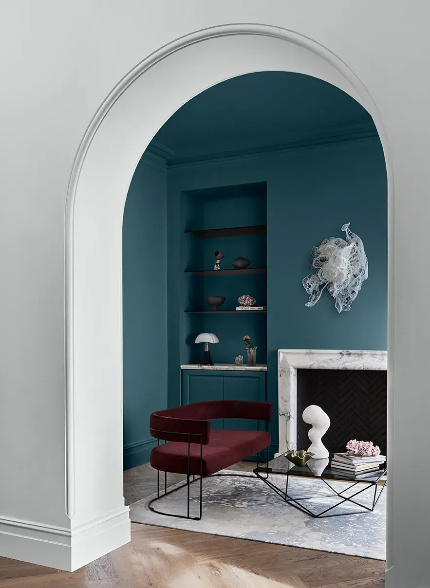 White arched doorway with view to blue living room
