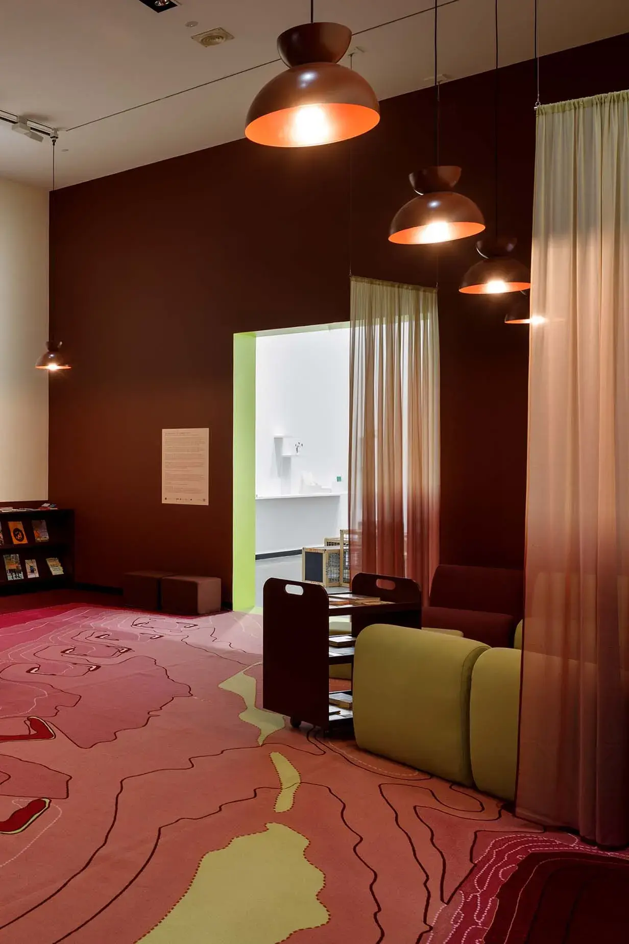 White and maroon reading room with lime green and maroon chairs and carpet