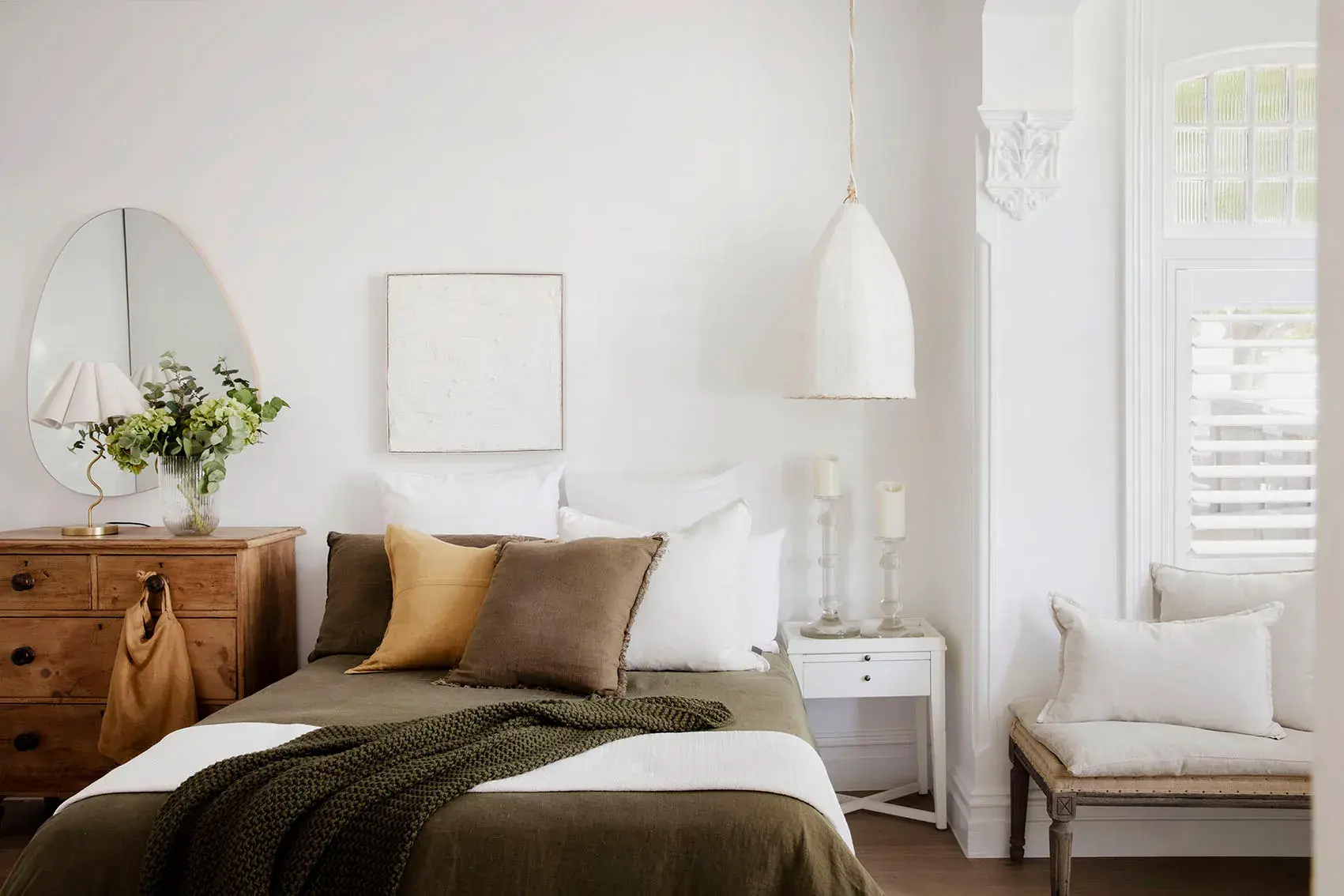 White bedroom with green and brown linens