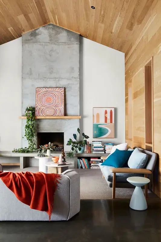 interior lounge room with wood and concrete fireplace.