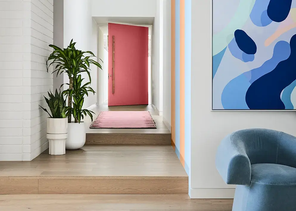 Hallway featuring pink door with blue and orange stripes on wall