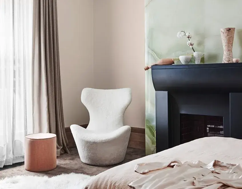 interior bedroom pink and green with fireplace and chair.